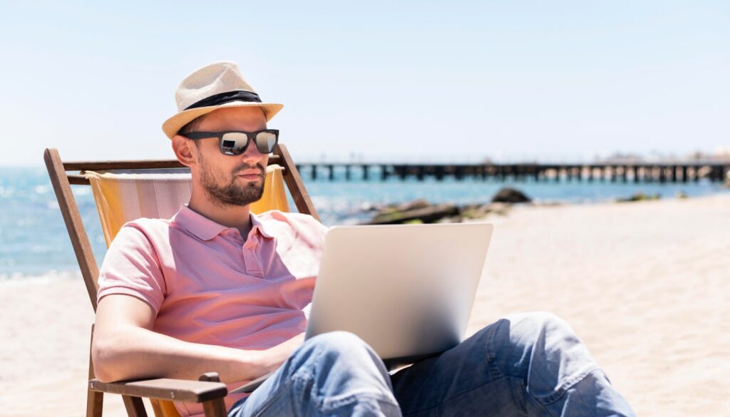 work in marbella man working laptop beach chair